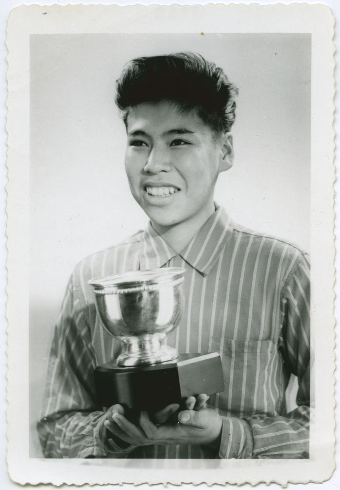 [Male student holding trophy]