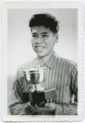 [Male student holding trophy]