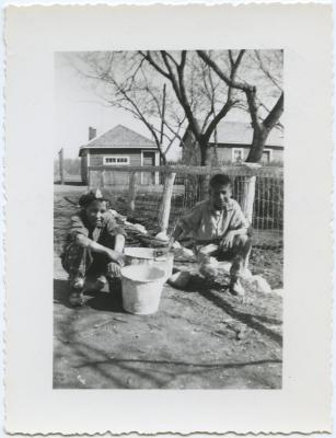 [Two boys who have finished white washing a fence, File Hills Residential School, Sask.]
