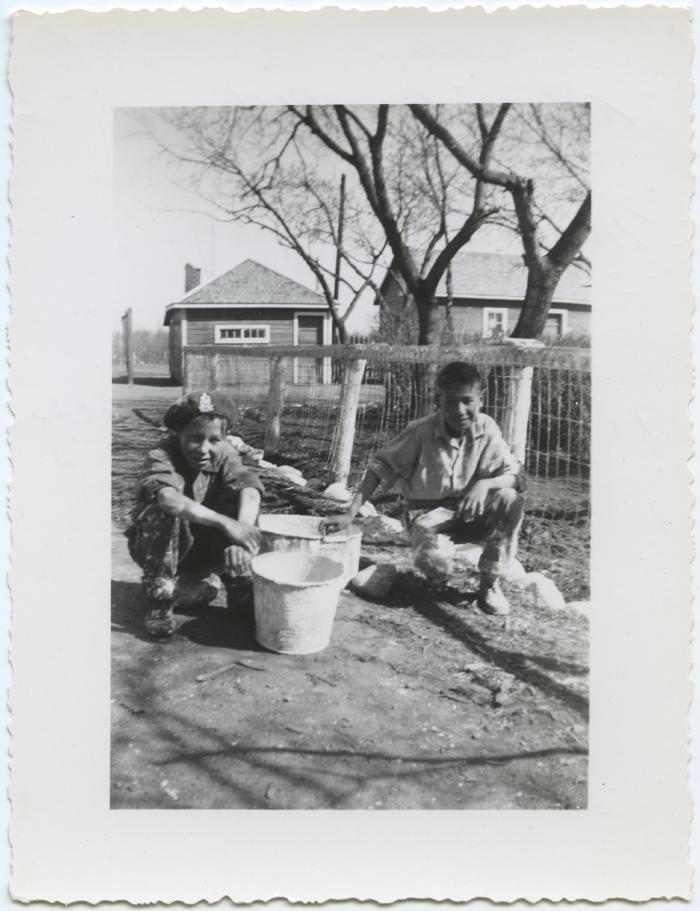 [Two boys who have finished white washing a fence, File Hills Residential School, Sask.]