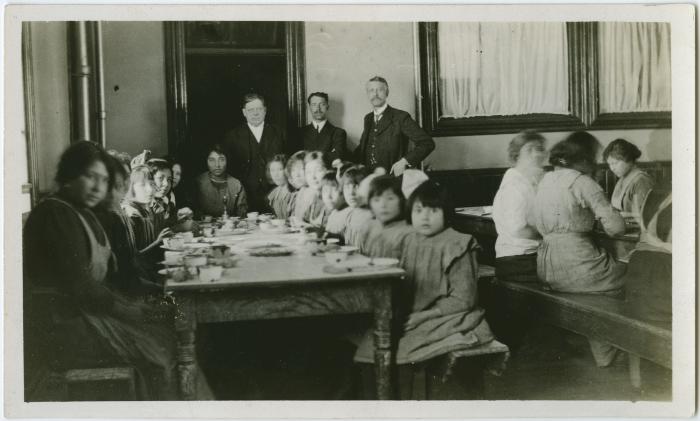 [Principal Ferrier and two staff members supervising students in the dining hall at dinner time, Brandon Institute]