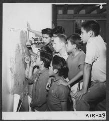 Alberni Indian Residence Alberni, B. C. Boys looking at map during study period. With them is their grade counsellor who looks after their general welfare.