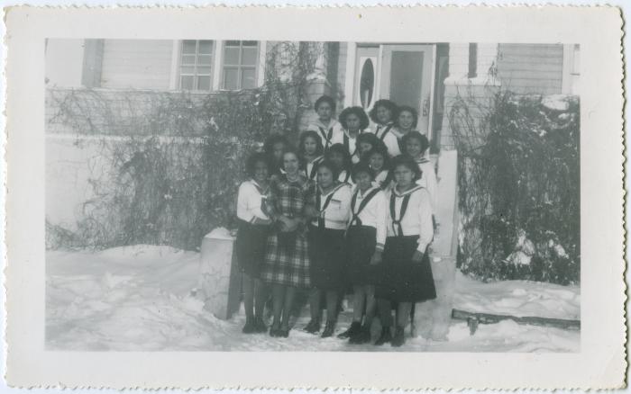 Allison McLean, the dietician, standing with C.G.I.T. girls in uniform, Round Lake Residential School, Sask.