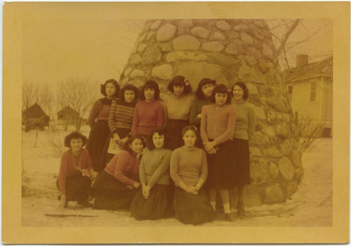 C.G.I.T. group in Sunday clothes with cairn back of them, Round Lake Residential School, Sask.