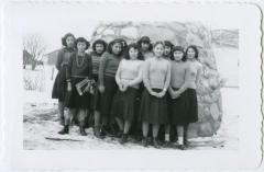 C.G.I.T. girls (not in uniform) in front of the cairn, Round Lake Residential School, Sask.