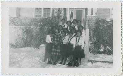 Allison McLean, the dietician, standing with C.G.I.T. girls in uniform, Round Lake Residential School, Sask.