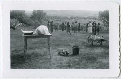 Mrs. Card and girls at an afternoon party with lunch waiting on the table, Round Lake Residential School, Sask.