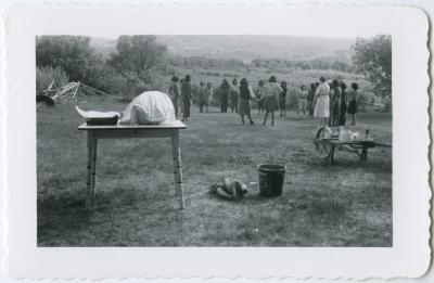 Mrs. Card and girls at an afternoon party with lunch waiting on the table, Round Lake Residential School, Sask.
