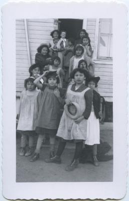 Mrs. Card and girls with their dress-up hats at their playroom door, Round Lake Residential School, Sask.