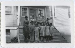 Some of the Indian children on the school steps with Alan Bell who was in the advanced room the first year I was at Round Lake, Sask.