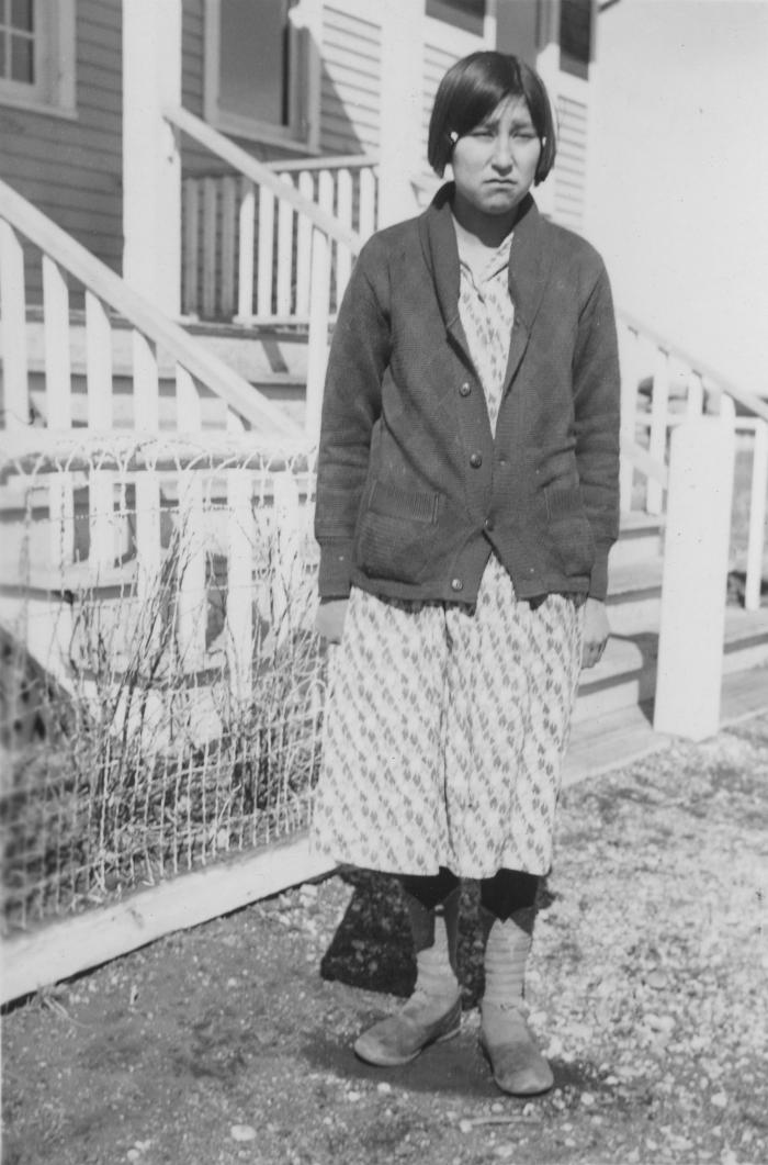 Stoney Nakoda girl in front of school building