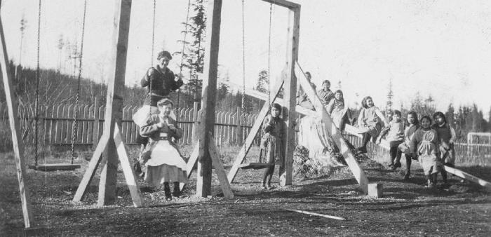 Girls' Home, Alert Bay, B.C. - Miss Sier (standing on swing), Miss Dibben (sitting on swing), and school girls
