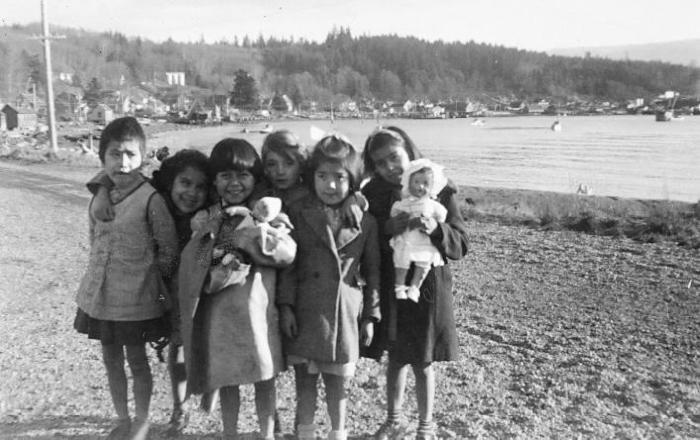 In Front of the School Gates.  Christine, Pauline, Lana, Jeanie, Eleanor and Kathleen.  The village church is all but hid behind a tree, just over Jeanie's head.