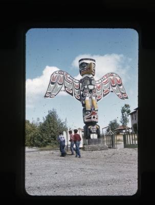 Three unidentified boys and a totem