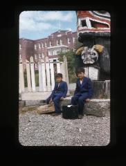 Two unidentified boys and a totem