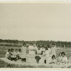 Little girls making mud pies in the sandbox at the Indian Boarding School, Norway House