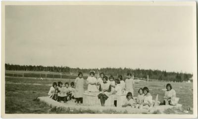 Little girls making mud pies in the sandbox at the Indian Boarding School, Norway House