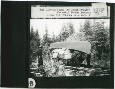 [Between Norway House and Oxford House, a distance of some two hundred miles, there were many portages, some as long as three miles : on this particular portage, there was a railroad track :  goods were loaded on to a small car which then had to be pulled : since there were no bridges one had to hold back just as hard going down hill as [one] had to pull going up]