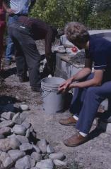 Art Solomon mortaring the stone wall, workman seated on circular wall where cairn is being constructed