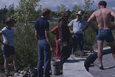 Elder Art Solomon, who is supervising the stone work on cairn, talks with some of the volunteers on the site, who are working on the construction