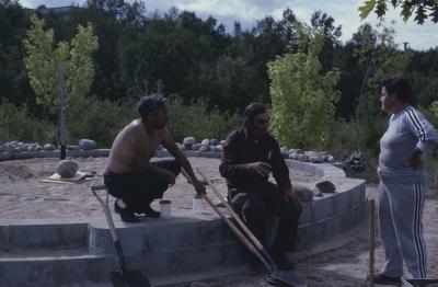 Elder Art Solomon, who is supervising the stone work on cairn, talks with some of the volunteers on the site, who are working on the construction