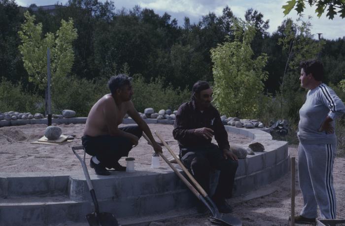 Elder Art Solomon, who is supervising the stone work on cairn, talks with some of the volunteers on the site, who are working on the construction