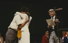 Anne Squire embracing Alf Dumont as they stand on platform after the constitution of ANCC and covenanting service