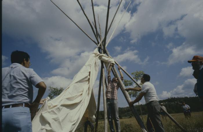 Grafton Antoine and friends erecting the teepees during the afternoon of General Council, on ground adjacent (part of) the University in Sudbury, which is built on traditional native land.