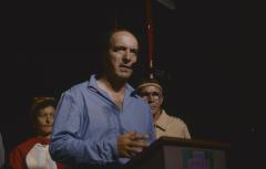 [Stan McKay speaking at a podium]