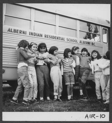 Alberni Indian Residence Alberni, B. C. Girls clowning around beside bus.