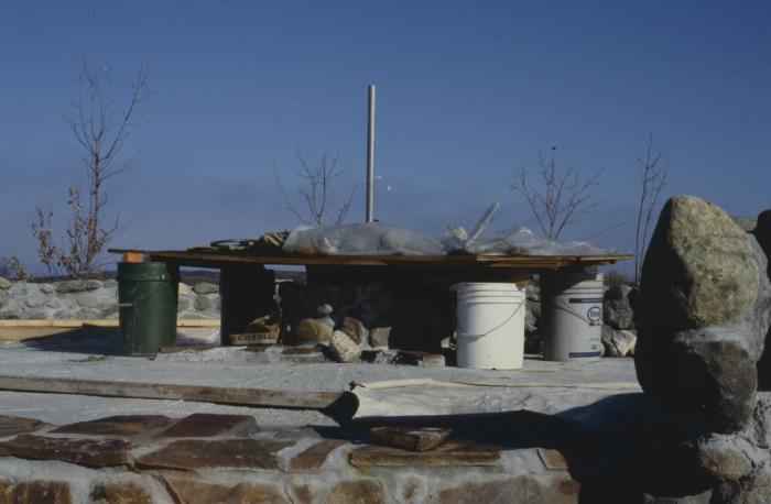 Construction of the low circular stone wall of [Apology cairn]