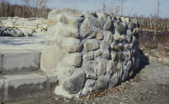 Construction of the low circular stone wall of [Apology cairn]