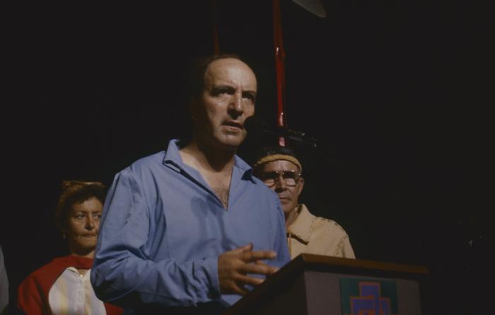 [Stan McKay speaking at a podium]