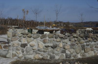 Construction of the low circular stone wall of [Apology cairn]