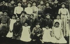 Native Canadian adults and children posing for a picture in the countryside