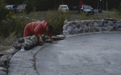 Maxine McVey of Sudbury helps with the construction and lays the stones on the circular stone wall [of the Apology cairn]