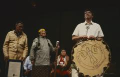Alf Dumont holding the symbol of the ANCC, speaking to the delegates to the 32nd General Council at the constitution of the ANCC and covenanting service.