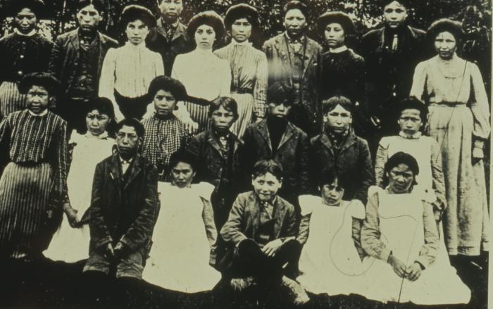 Native Canadian adults and children posing for a picture in the countryside